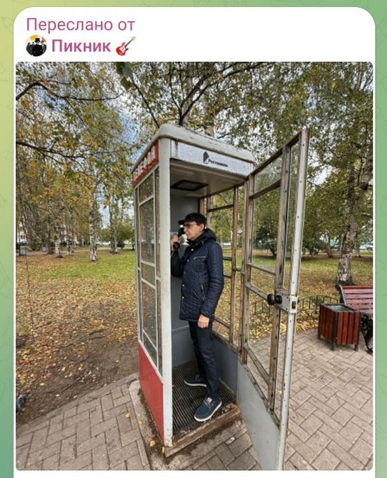 Лидер группы Пикник Эдмунд Шклярский звонит из старой телефонной будки Ростелеком в парке осенью Лидер группы Пикник Эдмунд Шклярский звонит из старой телефонной будки Ростелеком в парке осенью